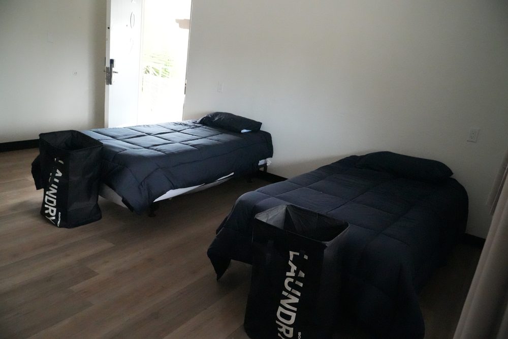 Two beds and a dresser in a HarborTAY room, ready for new residents